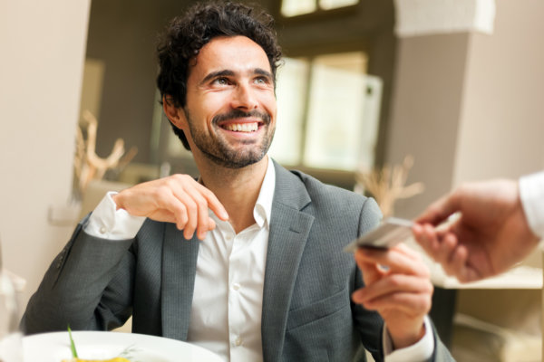 Man paying the bill a the restaurant with a credit card