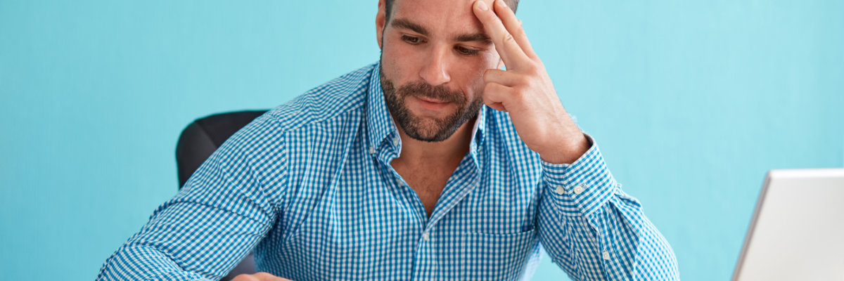 Pensive businessman calculates taxes at desk in office