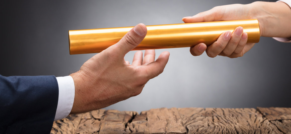 Close-up Of A Businessperson Passing Baton